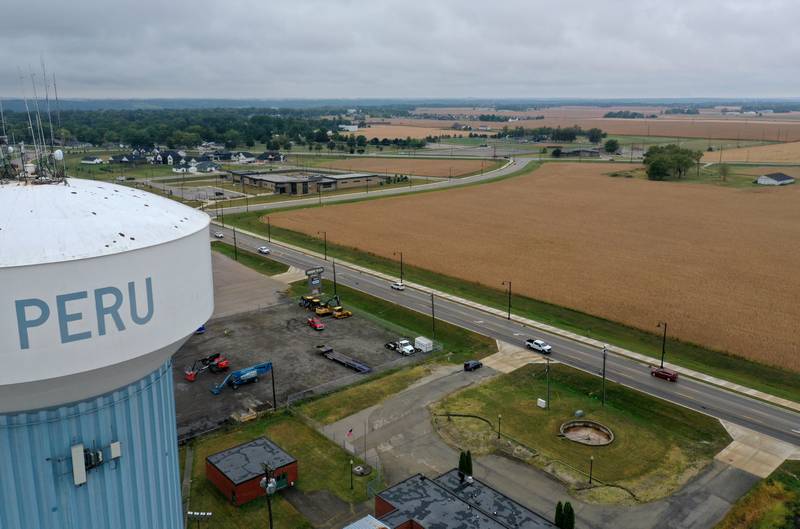 An aerial view looking west of the Peru water tower of a farm field near the intersection of Midtown Road and Peoria Street on Tuesday, Sept. 24, 2024 in Peru. The City of Peru released a drawing at the past city council meeting to give residents an idea of how a multi-faceted sports complex and city center may be laid out in Peru.