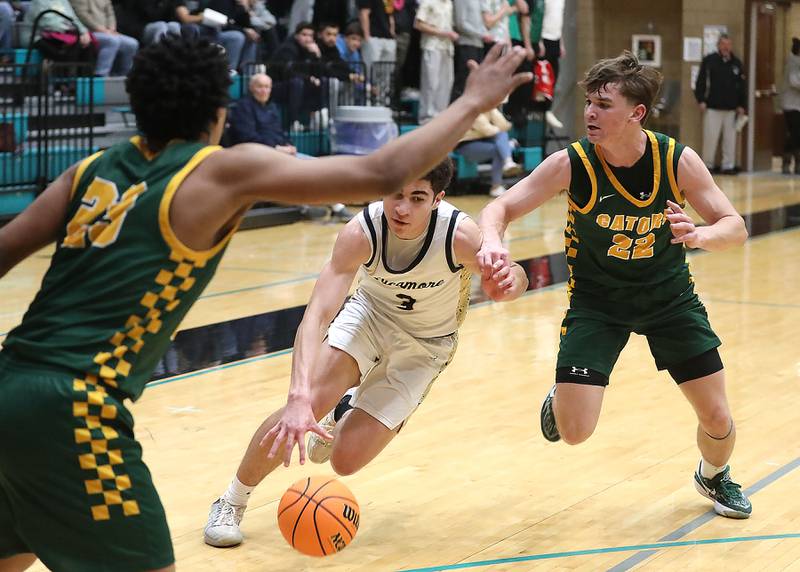Sycamore's Marcus Johnson drives between Crystal Lake South's David Mcfadden (left) and Crystal Lake South's Nick Stowasser during an IHSA Class 3A Woodstock North Sectional semifinal.basketball game on Wednesday, March 4, 2025, at Woodstock North High School.