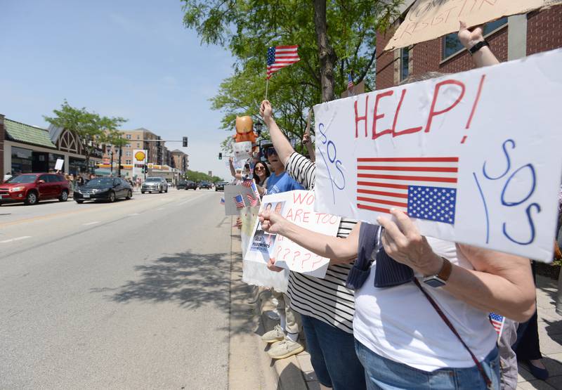 An SOS sign outside Elmhurst City Hall while people participate in the nationwide No Kings Day Rally Saturday June 14, 2025.
