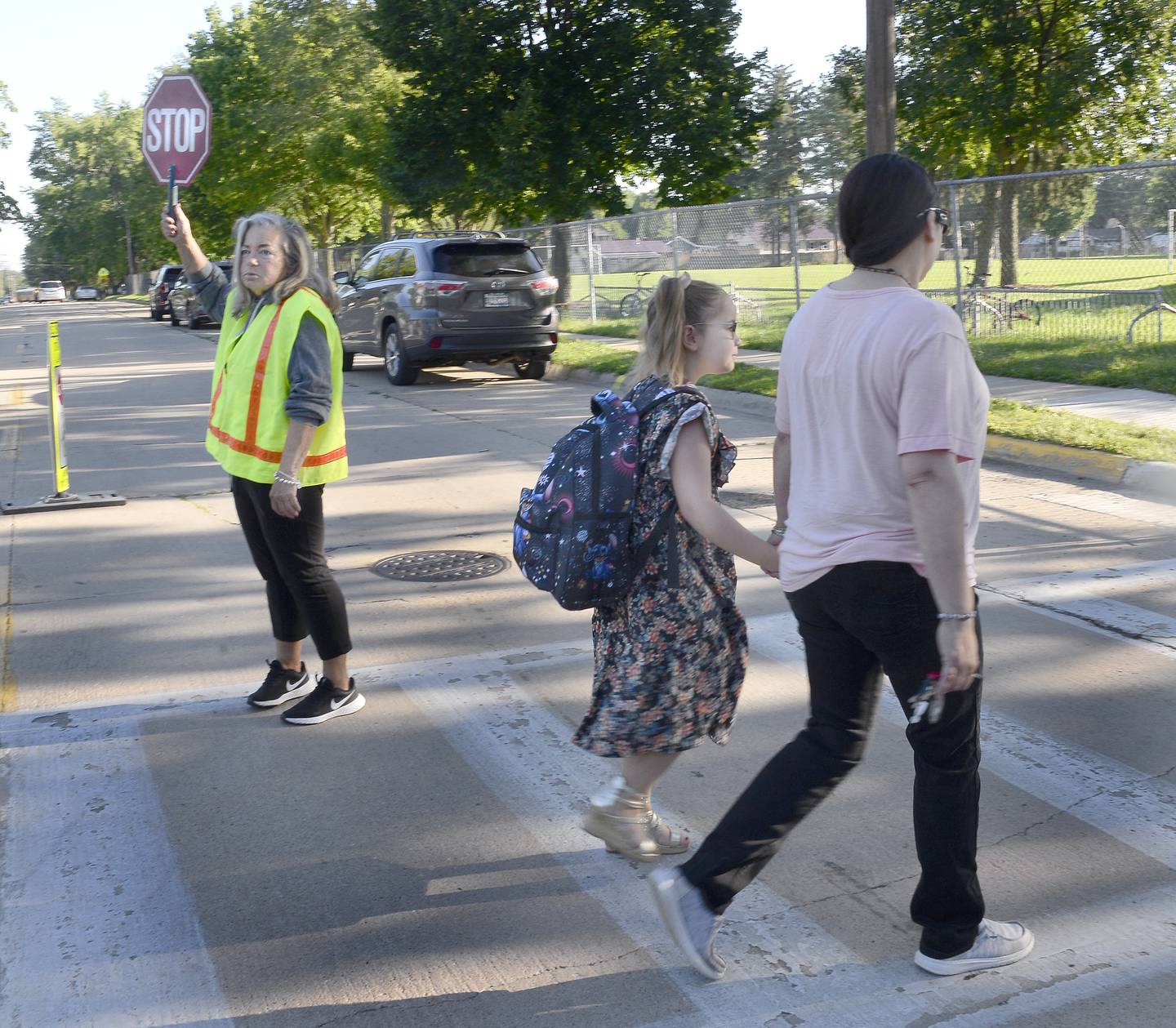 Crossing Guard Pam Sinclair stops traffic on State Street in Ottawa as parents and students arrive for the first day of classes Wednesday, Aug. 31, 2022, at McKinley School.