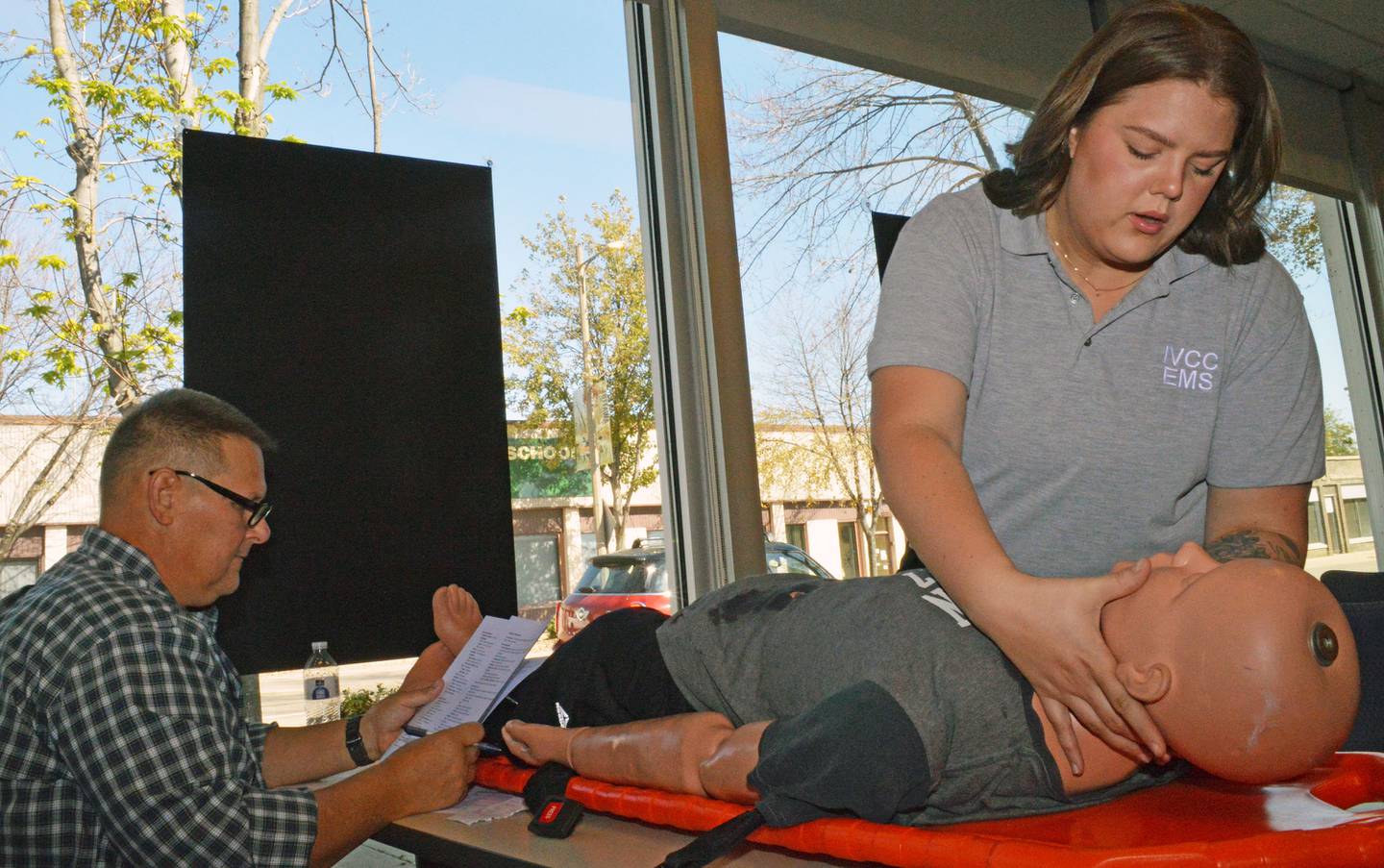 Lauren Bangert, a member of the Marseilles Ambulance squad, takes her final hands-on exam for the paramedic course at Illinois Valley Community College Ottawa Center under the watchful eye of Andy Borkowski. Students were asked to assess a victim of traumatic injuries as if they were on scene.