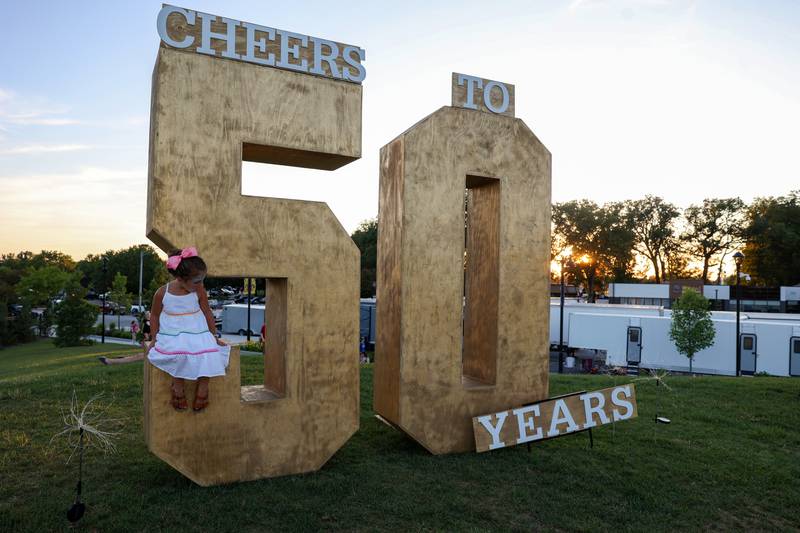 Vivi Ogrentz, 4, of Aroma Park, sits atop the display commemorating the 50th Bourbonnais Friendship Festival at The Grove on Saturday, June 28, 2025.