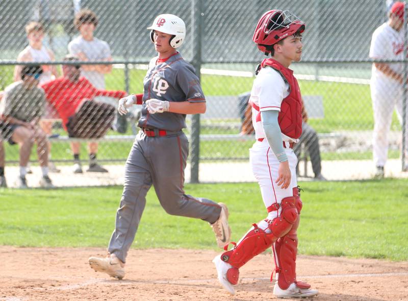 L-P's Jackson Piecha scores a run as Ottawa catcher Adam Swanson watches the play on Friday, May 2, 2025 at Ottawa High School.
