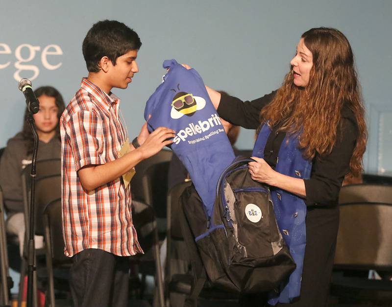 Vishrut Kinikar receives some of his prizes for winning the McHenry County Regional Office of Education 2023 Spelling Bee from McHenry County Regional Superintendent Diana Hartmann on Wednesday, March 22, 2023, at McHenry County College's Luecht Auditorium in Crystal Lake.