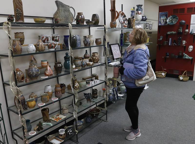 Diane Ray of Woodstock shops on Thursday, Dec. 19, 2024, at Artisans on Main in Woodstock. Several of the artists have holiday themed items for sale.