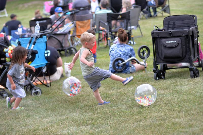 Two children, Theo Patrol and Eva Granada, play with one of the plastic balls given away by Stillman Bank during the Oregon Park District's Concert in the Park on Tuesday, June 17, 2025 at Oregon Park West.  Stillman sponsored the band "That Gurl" in what was the opening week of the free concerts.