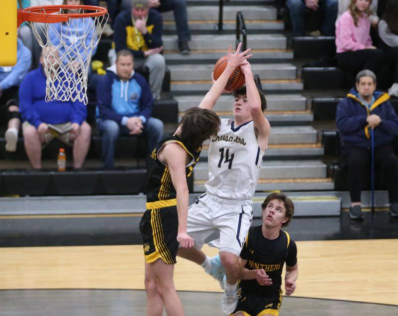 Marquette's Carson Zellers shoots a jump shot over Putnam County's Gavin Cimei and Bryce Smith during the Tri-County Conference Tournament on Tuesday, Jan. 23, 2024 at Putnam County High School.