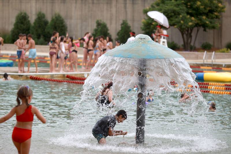 Patrons play in the water at the Batavia Park District’s Hall Quarry Beach on Thursday, June 13, 2024.