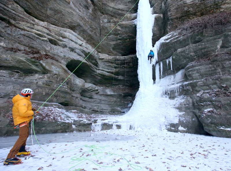 Jared Betcher (top) climbs down an 80-foot frozen waterfall as Gerry Voelliger (bottom)  assists inside Wildcat Canyon on Friday, Jan. 24, 2025, at Starved Rock State Park. The waterfalls tend to freeze in January at Matthiessen and Starved Rock state parks. Climbers need to sign in and out at the front of the Park Maintenance Building across from the Visitor Center. Climbing is only allowed in four canyons at the park.