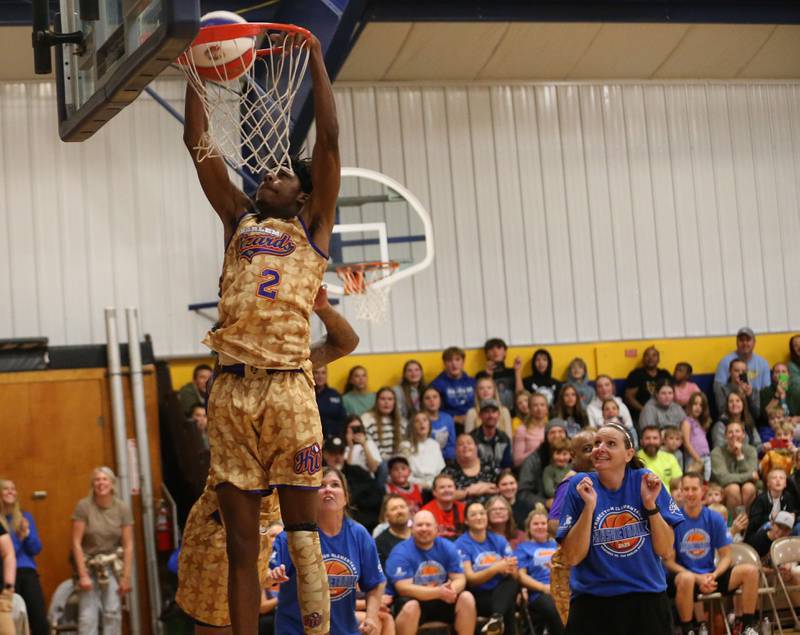 Harlem Wizards player Devale Johnson, (Too Tall) dunks the ball as Douglas School paraprofessional Brittany Sledgister reacts during the Harlem Wizards event on Tuesday, Oct. 28, 2025 in Pannebaker Gymnasium at Logan Jr. High School in Princeton.