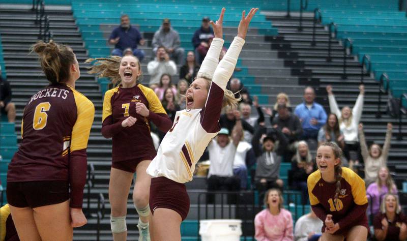 Richmond-Burton’s Lanie Cooley, center, and Alex Hopp, left, erupt at the conclusion of a three-set win in varsity volleyball at Woodstock North Monday night.