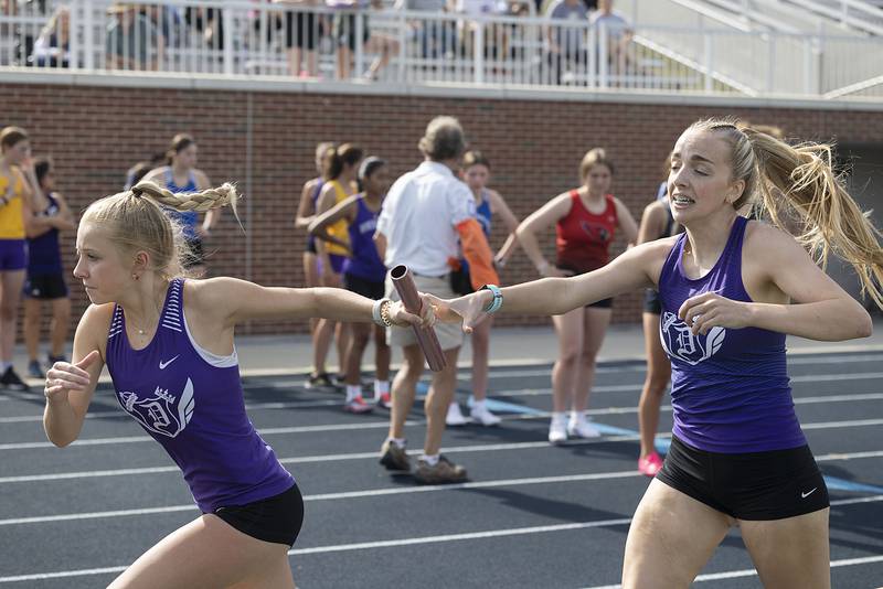 Dixon’s Kait Knipple hands the baton off to Kate Boss in the 4x800 Thursday, May 11, 2023 at the class 2A Sterling girls track sectionals.