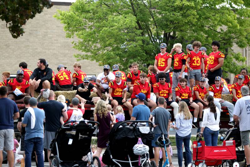 Batavia High School football players ride atop a flatbed trailer during the school’s annual homecoming parade on Wilson Street on Wednesday, Sept. 20, 2023.