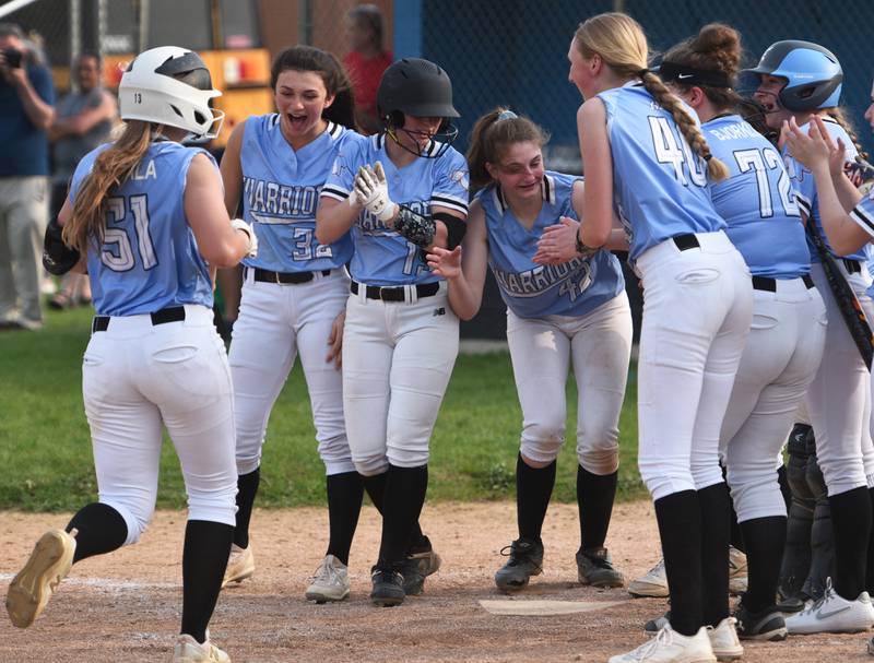 Willowbrook's Sonia Ruchala (51) hit a home run in the third inning and is greeted at home plate during Wednsday's softball game against Addison Trail in Villa Park.