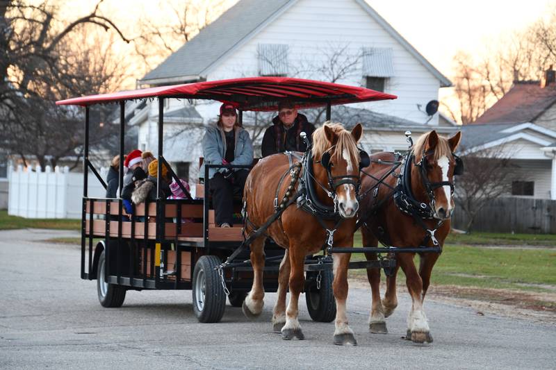 A horse drawn carriage takes visitors around town during Ladd's Christmas Walk on Saturday, Dec. 11, 2021