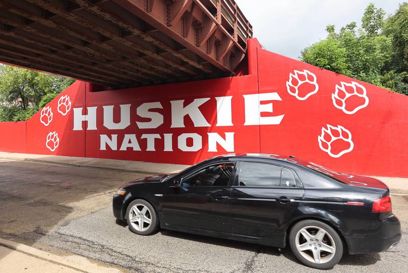 A car drives by part of the new Huskie mural Monday, Aug. 14, 2023, on the Annie Glidden Road railroad underpass, just south of Lincoln Highway in DeKalb. The mural was a joint project between the City of Dekalb and Northern Illinois University.