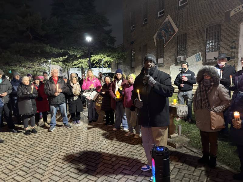 The Rev. Joseph Mitchell (right) speaks during a candlelight memorial vigil as a large crowd watches in downtown DeKalb on Friday, Jan. 9, 2026. Organizers planned the vigil to remember the life of Minnesota mother Renee Nicole Good, 37, who was shot and killed by a federal immigration agent in Minneapolis on Wednesday.