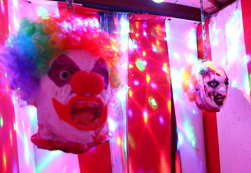 Clown faces drop from the ceiling to the entrance to the clown room at the Insanity Haunted House at the Peru Mall on Monday Sep. 27, 2021.
