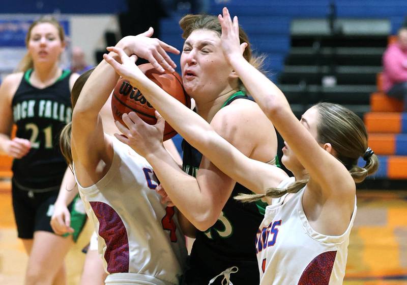 Rock Falls' Claire Bickett tries to get through Genoa-Kingston's Sydney Hansen (left) and Presley Meyer during their game Friday, Feb. 2, 2024, at Genoa-Kingston High School.