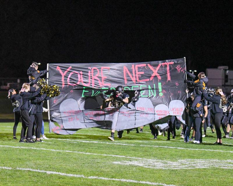 Sycamore Colton Read (84) breaks through the banner before the start of the first week of play offs while taking on Evergreen Park at Sycamore High School on Friday Oct. 27, 2023.