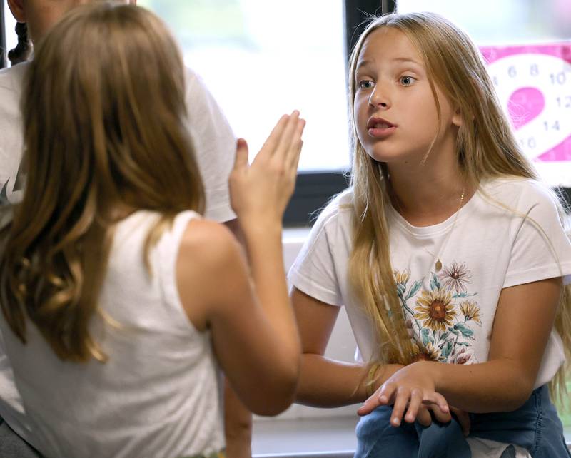 Reagan Davekos, (right) a fifth grader at Genoa Elementary School, talks to a classmate during the first day of school Wednesday, Aug. 16, 2023, in their class at the school.