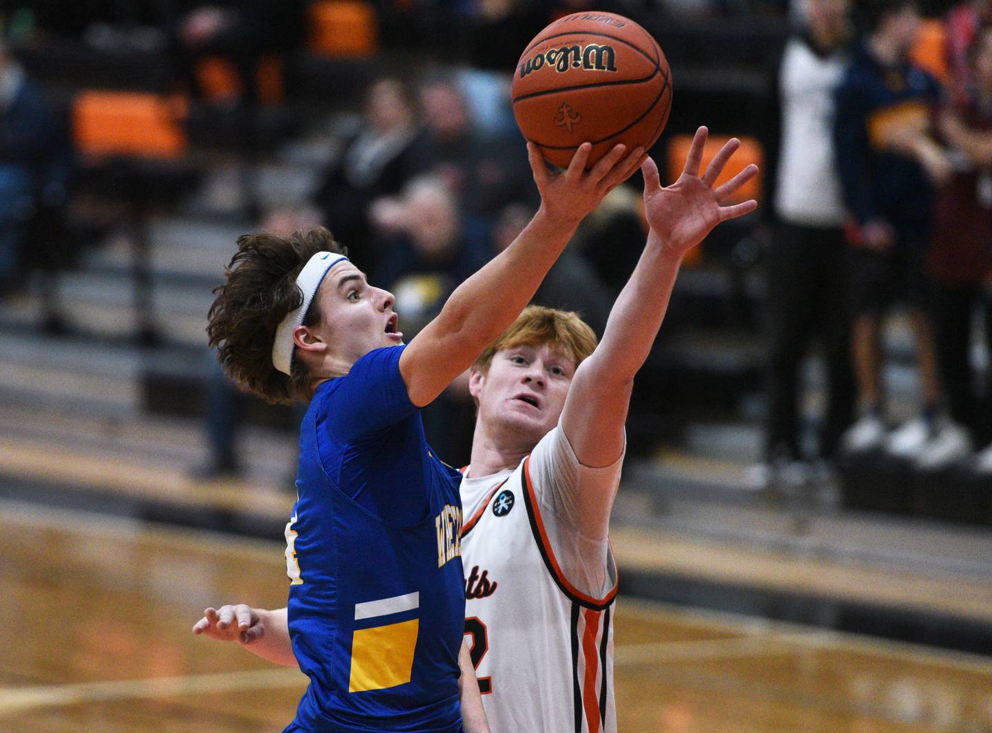 Wheaton North's Hudson Parker, left, takes a shot past St. Charles East's Brad Monkemeyer during Wednesday’s boys basketball game in St. Charles.