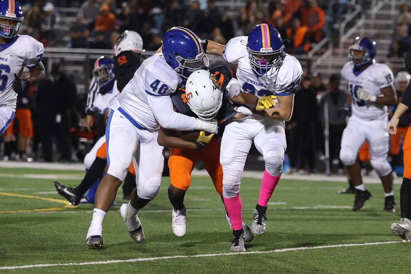 Joliet Central’s Dakota Kelly, left, and Dimarius Matthews bring down Plainfield East’s Devin Jones on Oct. 4, 20234 in Plainfield.