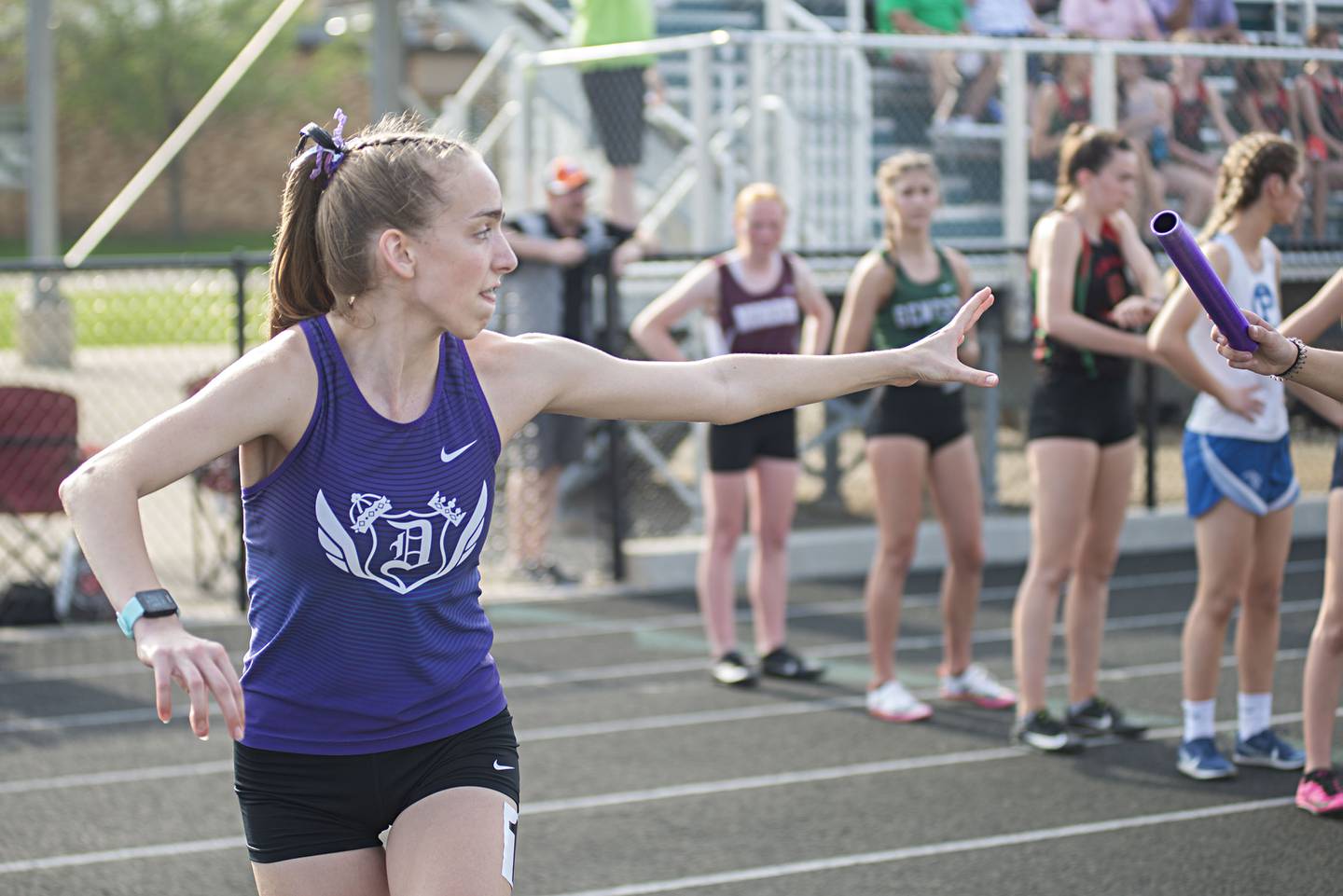 Dixon's Kait Knipple reaches back for the baton for the final run in the 4x800 at the 2A track sectionals in Geneseo on Wednesday, May 11, 2022. Dixon won the event.