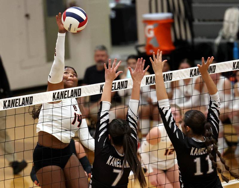 DeKalb's Jordan Grant tries to spike the ball by Kaneland's Brielle Gadomski (left) and Natalie Remsen Thursday, Sept. 4, 2025, during their match at Kaneland High School in Maple Park.
