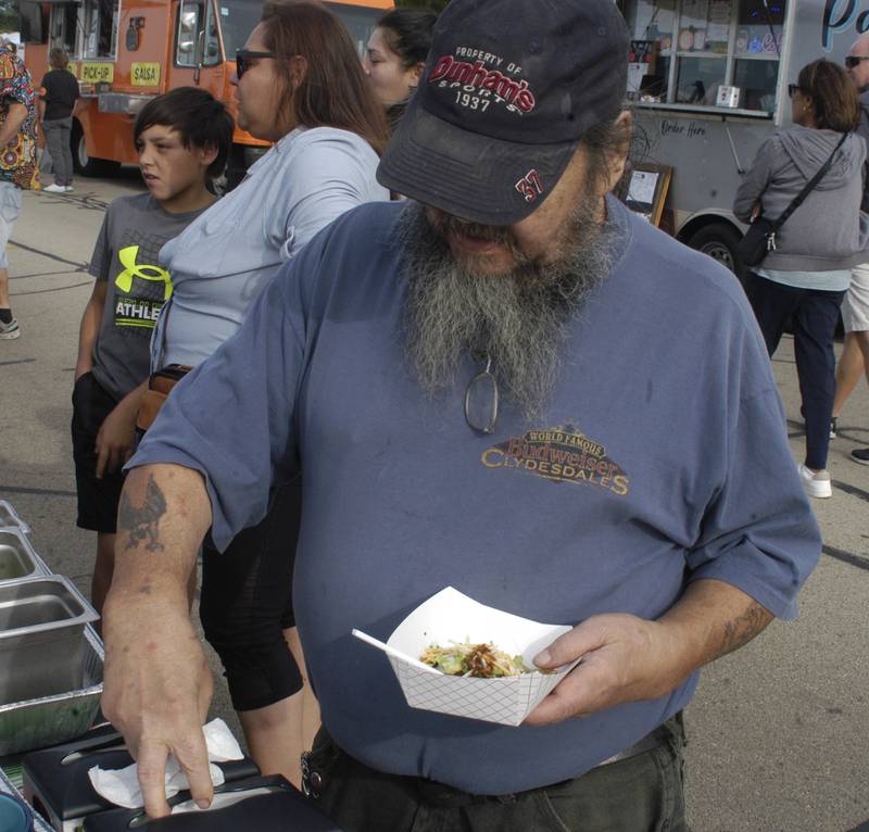 Jerry Collins of Sterling puts finishing toppings on  his tacos at the Taco Throwdown Events sponsored by Rock Falls Tourism at RBW District September 27th, 2024.