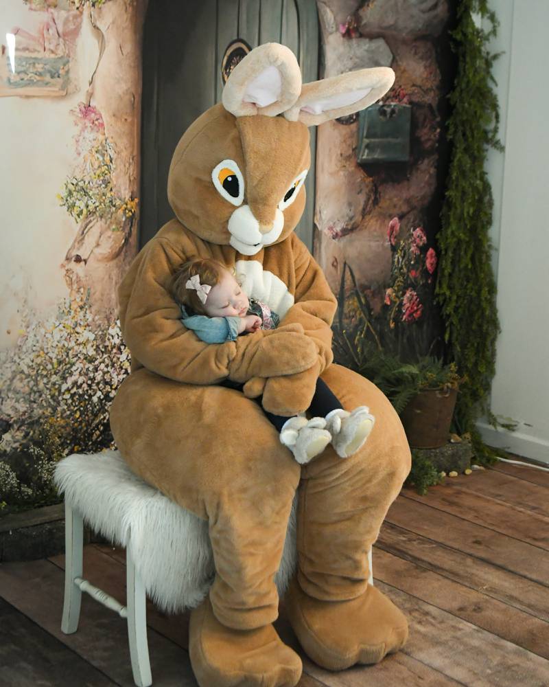Rowen Murray, 10 months, of Montgomery gets her photo taken with the Easter Bunny during the annual bunny hop on Saturday April 12, 2025, held in downtown Oswego.