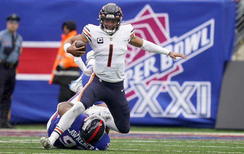 Chicago Bears quarterback Justin Fields (1) is sacked by New York Giants defensive tackle Dexter Lawrence (97) during the second quarter of an NFL football game, Sunday, Oct. 2, 2022, in East Rutherford, N.J. (AP Photo/John Minchillo)