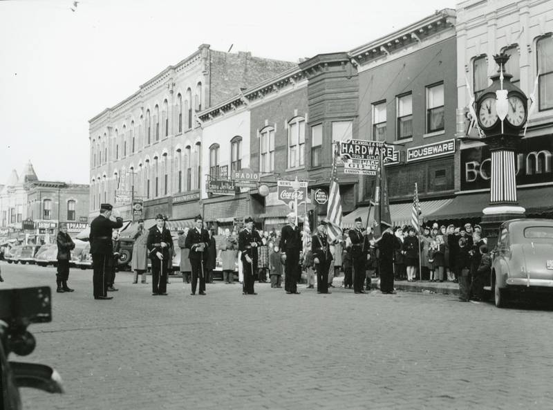 The American Legion and the Veterans of Foreign Wars memorialize Armistice Day November 11, 1941, by firing a salute at the Memorial Clock in DeKalb. The organizations then attended a program the Egyptian Theatre. Courtesy of the DeKalb County History Center Archives.