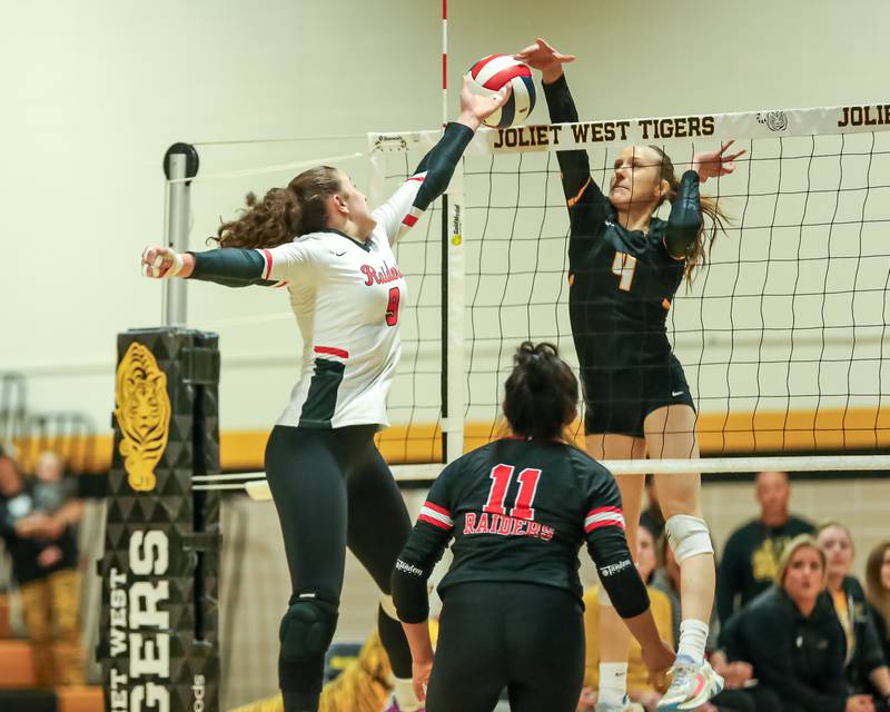 Bolingbrook's Noelle Aprati (9) meets Joliet West's Lina Govoni (4) at the net during regional final volleyball match between Bolingbrook at Joliet West.  Oct 26, 2023.