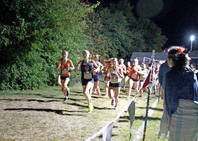 Varsity girls compete in the Naperville North Twilight Cross Country Invitational on Wednesday, Oct. 9, 2024 in Naperville.
