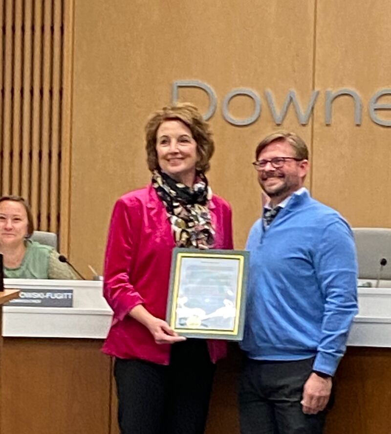 Downers Grove Commissioner Greg Hose, right,  presents Mary Ellen Young with a village proclamation recognizing her being named the recipient of the 2024 Montrew Dunham Award.