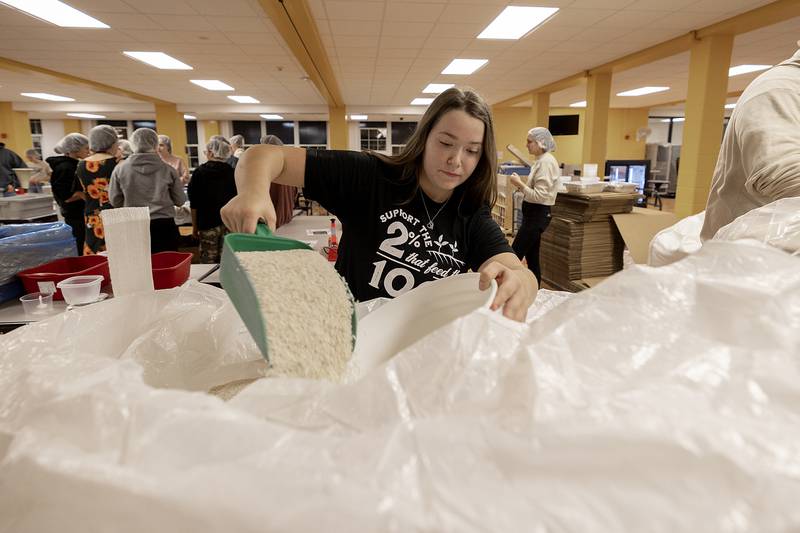 Sterling FFA Sentinel Kadielynn Nelson adds rice to a bucket from a giant bag Wednesday, Nov. 6, 2024, at Sterling High School.