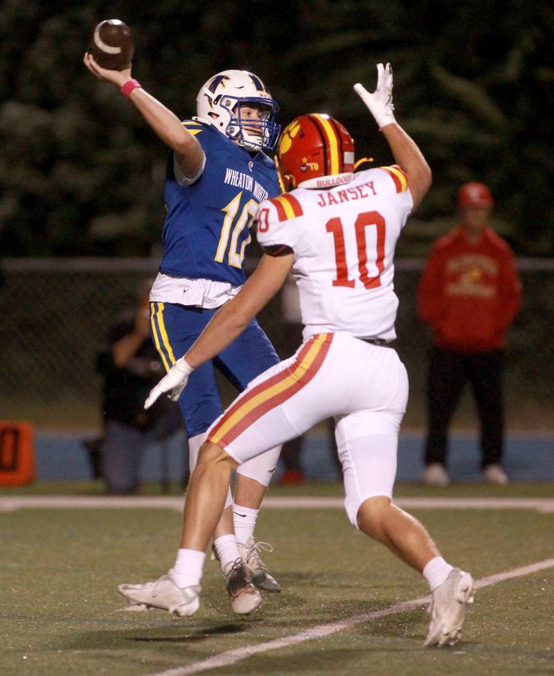 Wheaton North quarterback Nick Johnson throws the ball under pressure by Batavia’s Jacob Jansey during a game on Friday, Sept. 27, 2024 at Wheaton North.