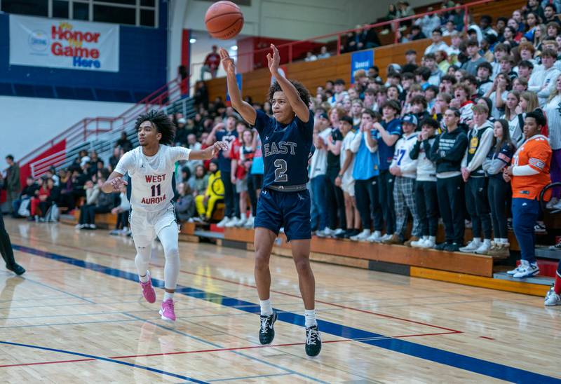 Oswego East's Bryce Shoto (2) shoots a three-pointer against West Aurora's Jordan Brooks (11) during a basketball game at West Aurora High School on Friday, Jan 27, 2023.