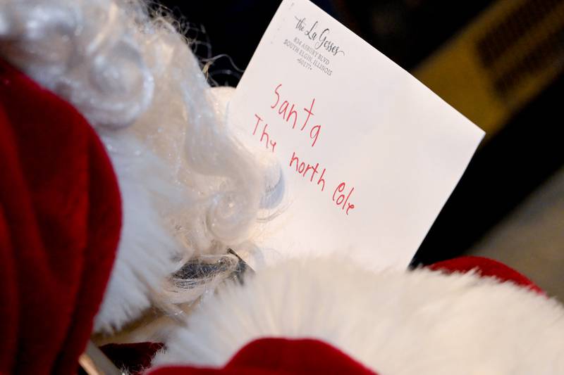 Santa receives a letter from a child during a visit to SantaÕs Workshop the Geneva Visitor Center on Saturday, Dec 20, 2025 in Geneva.