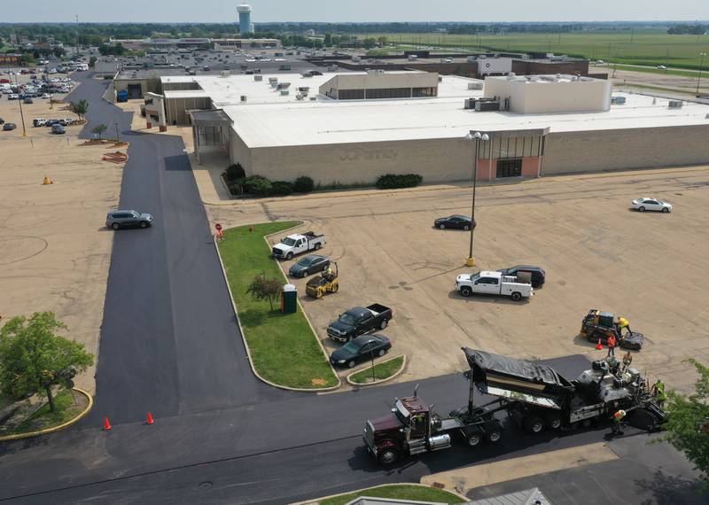 Workers with Advanced Asphalt pave the north entrance to the Peru Mall on Monday, July 17, 2023 in Peru. The project is on private property and is not city funded.