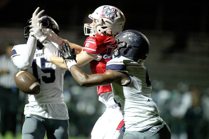 Marian Central’s Jacob Sievert, center, battles Chicago Hope’s Freddie Wood, left, and Jamari West for a pass which fell incomplete  in varsity football at Woodstock Friday night.
