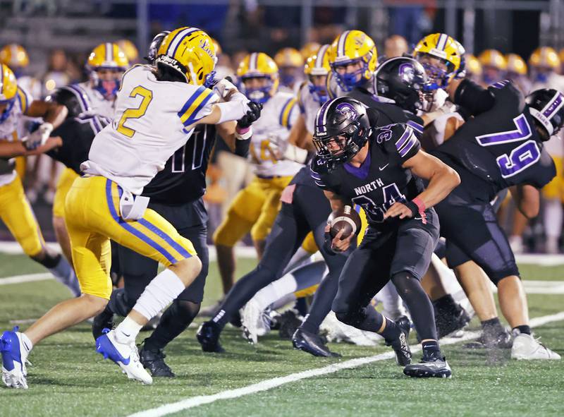 Downers Grove North's Jake Gregorio (34) looks for the hole to begin his touchdown run during the varsity football game between Downers Grove North and Lyons Township on Friday, Oct. 11, 2024 in Downers Grove.