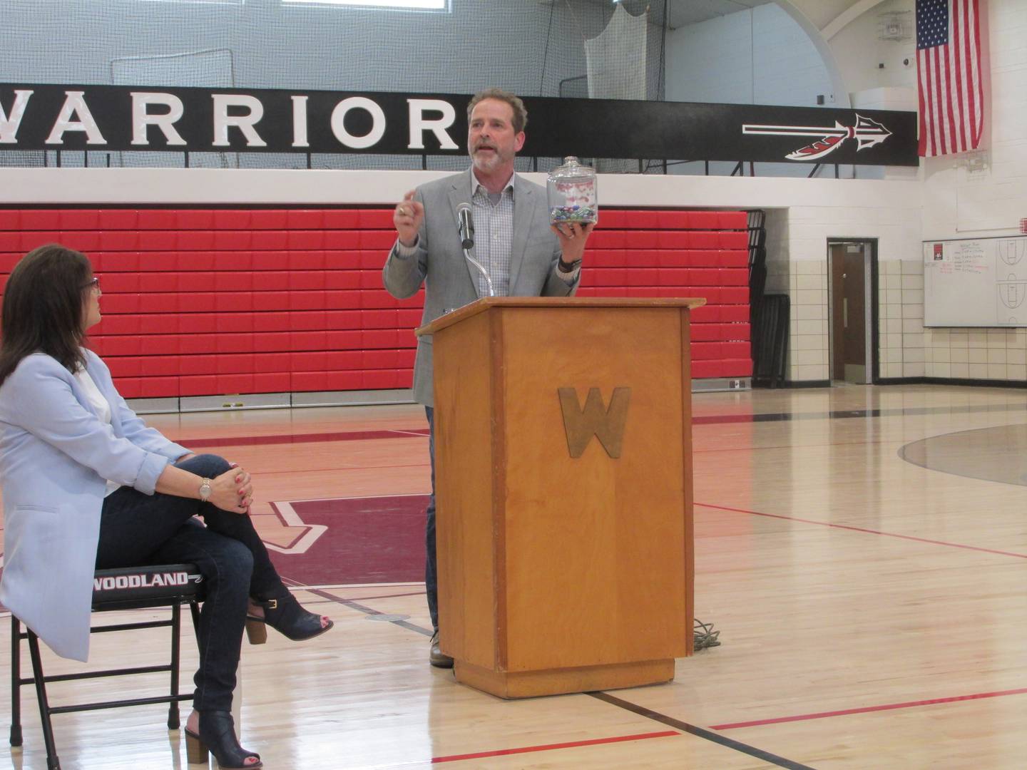 Woodland hall of fame inductee Michael Mallick uses a jar of marbles to describe how time passes by Friday, April 14, 2023, during a talk with students at the school's gymnasium.