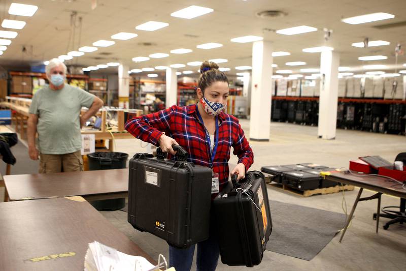 Yuridiana Tavizon unloads voting machines from polling places throughout Kane County at one of the county's rally centers for tabulating ballots on Nov. 3 in St. Charles.