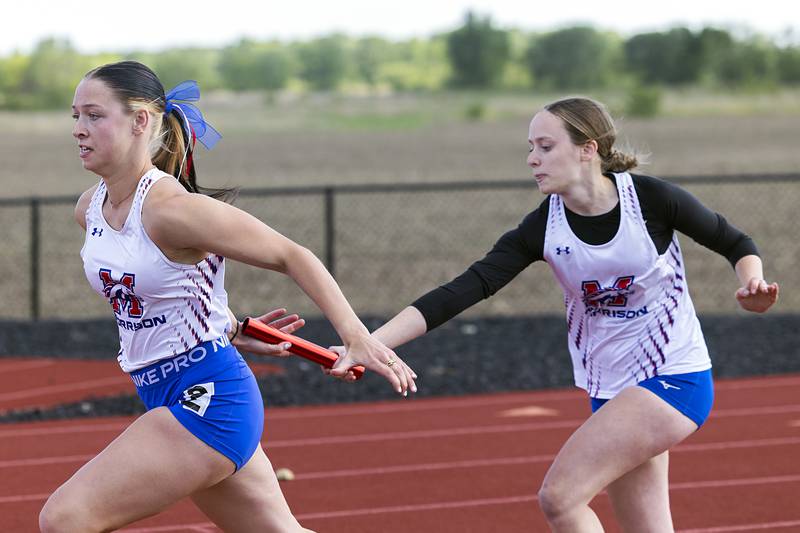 Morrison’s Lexi Walters (left) takes the baton from Caroline Derycke in the 4x100 Wednesday, May 13, 2026, during the Class 1A Erie Sectional meet.