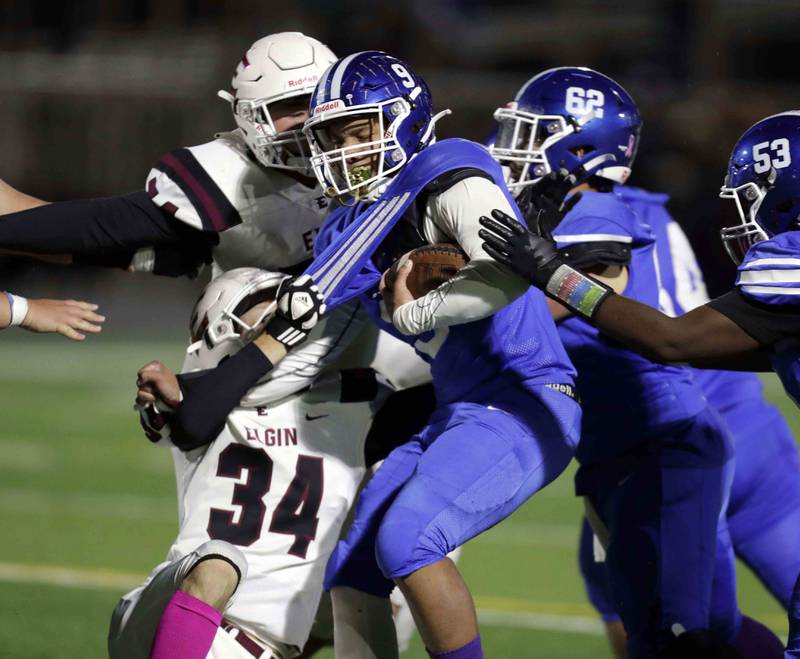 Larkin's Jalen Miller (9) has his jersey pulled by Elgin’s Nick West (34) during the annual crosstown rival game at Memorial Field  Friday October 14, 2022 in Elgin.