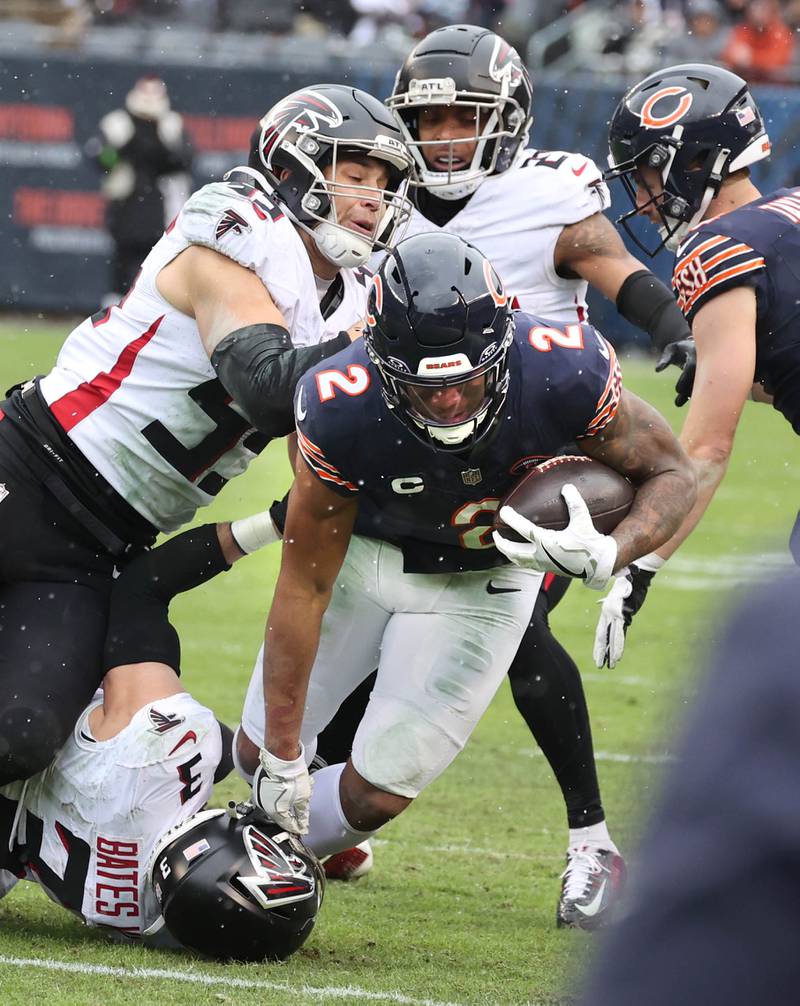 Chicago Bears wide receiver DJ Moore dives for extra yardage as Atlanta Falcons safety Jessie Bates III and linebacker Kaden Elliss bring him down during their game Sunday, Dec. 31, 2023, at Soldier Field in Chicago.