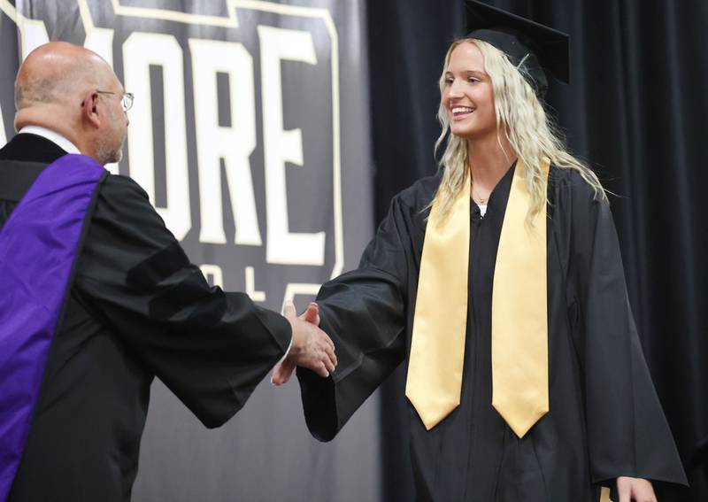Evyn Carrier is congratulated by Board of Education President James J. Dombek as she receives her diploma during commencement ceremonies Sunday, May 28, 2023, at Sycamore High School.