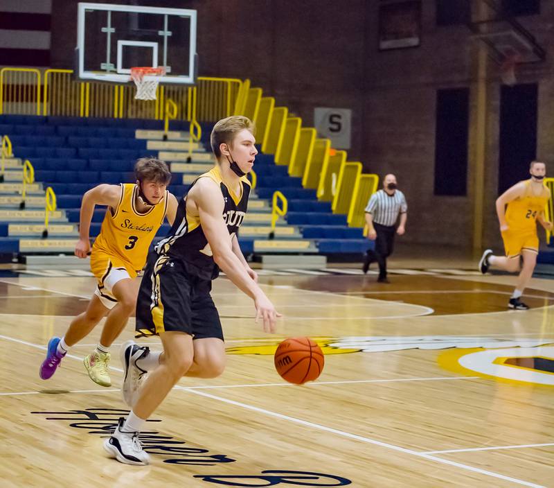 Hinsdale South's Garrett Bolte dribbles the ball as Sterling's Kyle Billings (3) trails on the play during their Sterling MLK tournament game Saturday evening at Musgrove Fieldhouse.